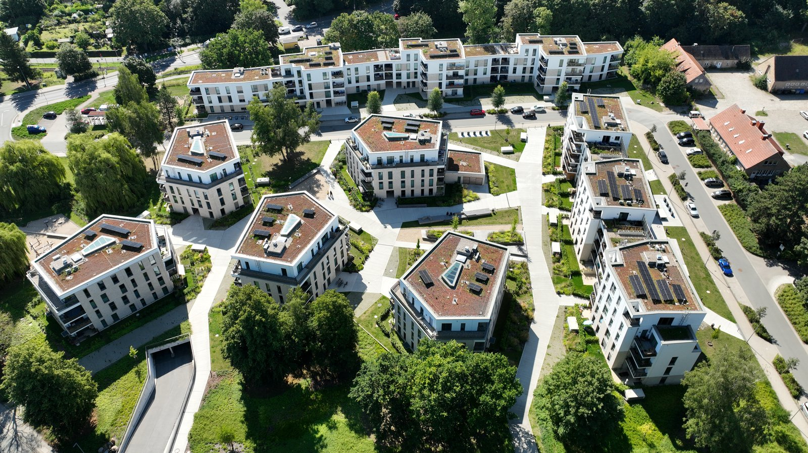 Luftaufnahme der Wohnanlage Thierfelder Straße in Rostock mit Photovoltaikanlagen auf begrünten Flachdächern
